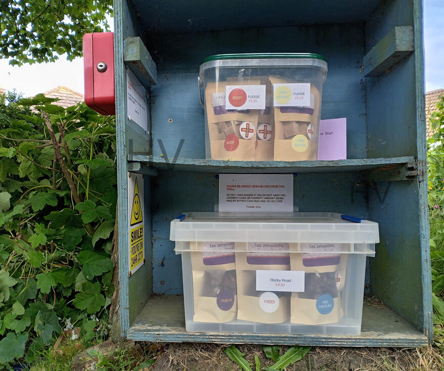 Les Traudes stall selling home made fudge in guernsey wooden shed surrounded by roses